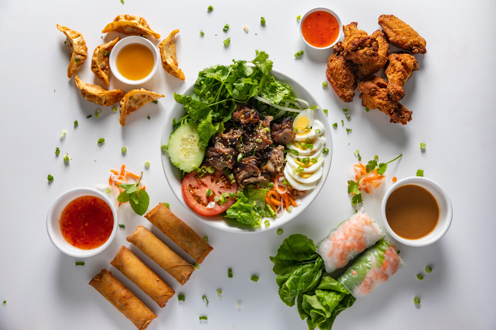Appetizer spread: potstickers, chicken wings, imperial rolls, fresh spring rolls and dipping sauces