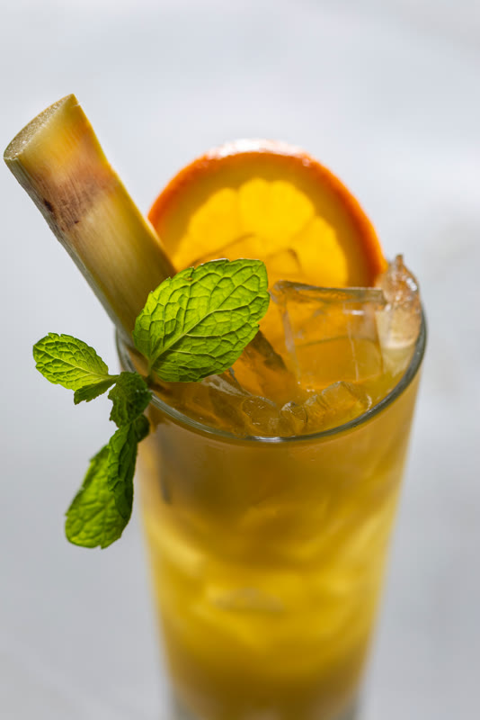 Fresh sugarcane juice with sugarcane stick and orange