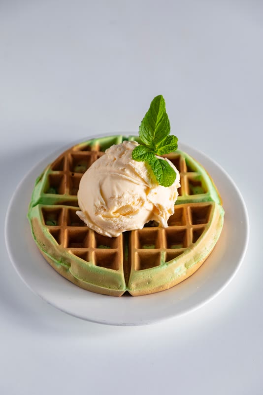 Pandan leaf coconut waffle topped with vanilla ice cream and mint